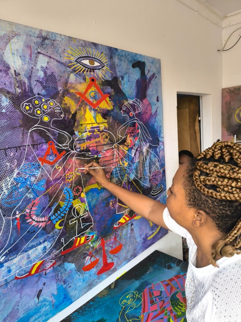 Setonou Djédatin peignant dans son atelier à Ouidah